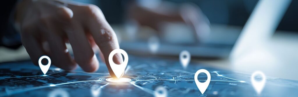 O que é o Geofencing e quais os benefícios para as empresas? 1 A mão de uma pessoa a tocar num tablet que mostra um mapa digital com múltiplos pontos de localização iluminados. A imagem representa o uso de um software de gestão de frotas para geolocalização, geofencing e monitorização GPS de ativos ou veículos em tempo real.